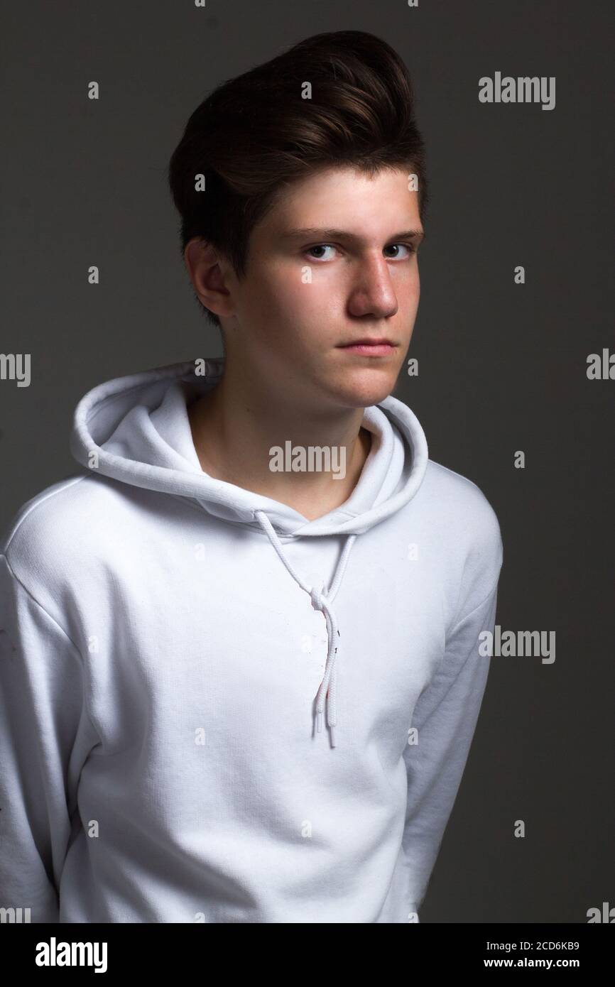 a boy in a white hoodie. Studio portrait on a black background Stock Photo