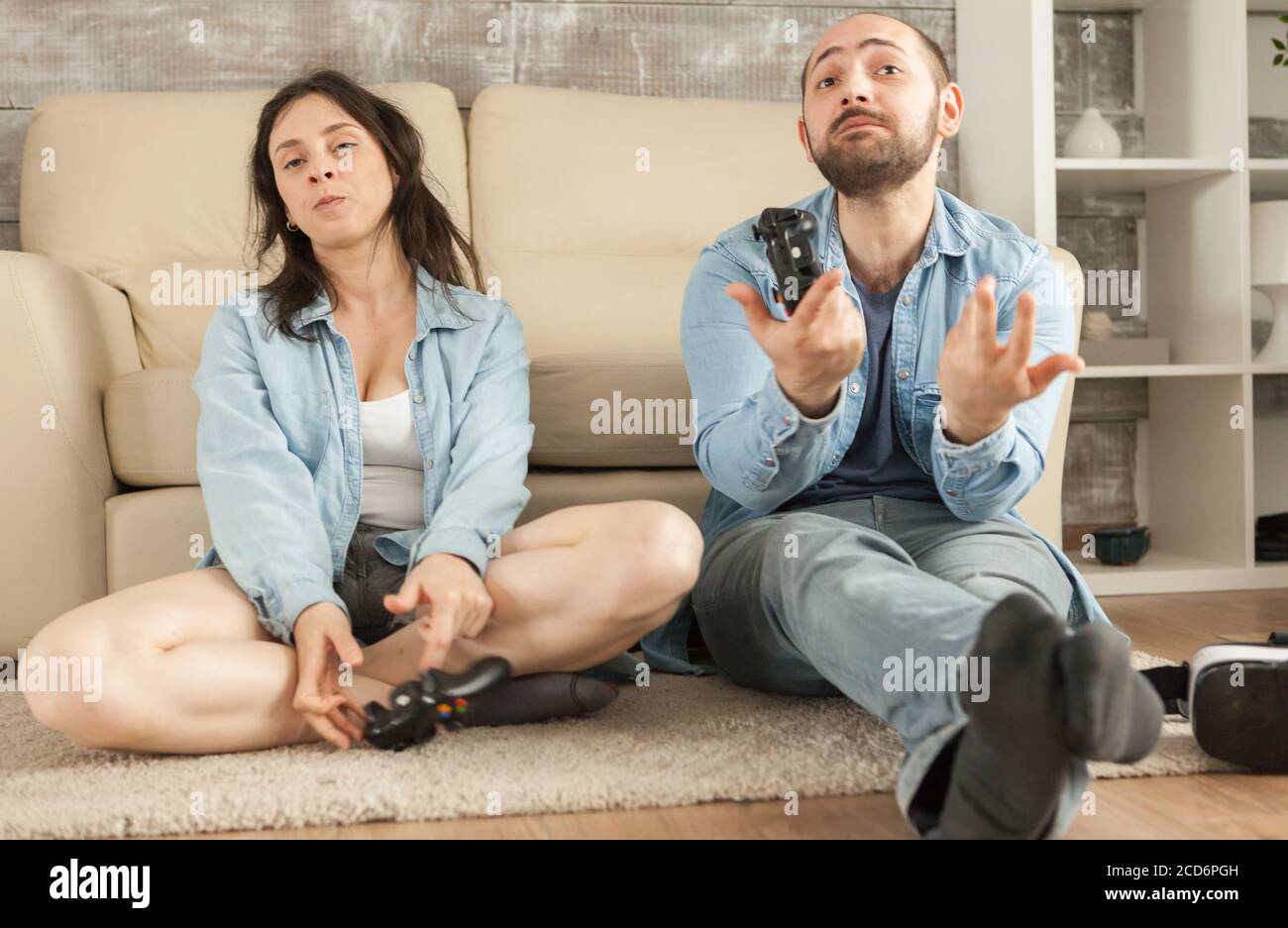 Couple losing at online video games using wireless controllers. Stock Photo