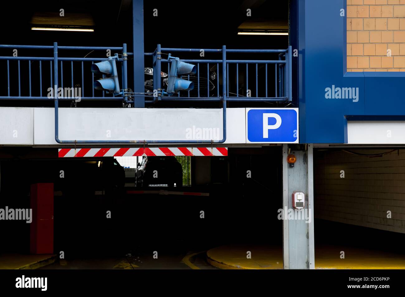 Entrance of a car parking garage with signal lights and blank sign