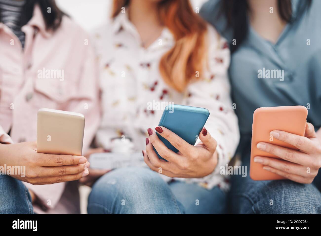 Group friends using mobile smartphone outdoor - Millennial young people having fun with new social media technology Stock Photo