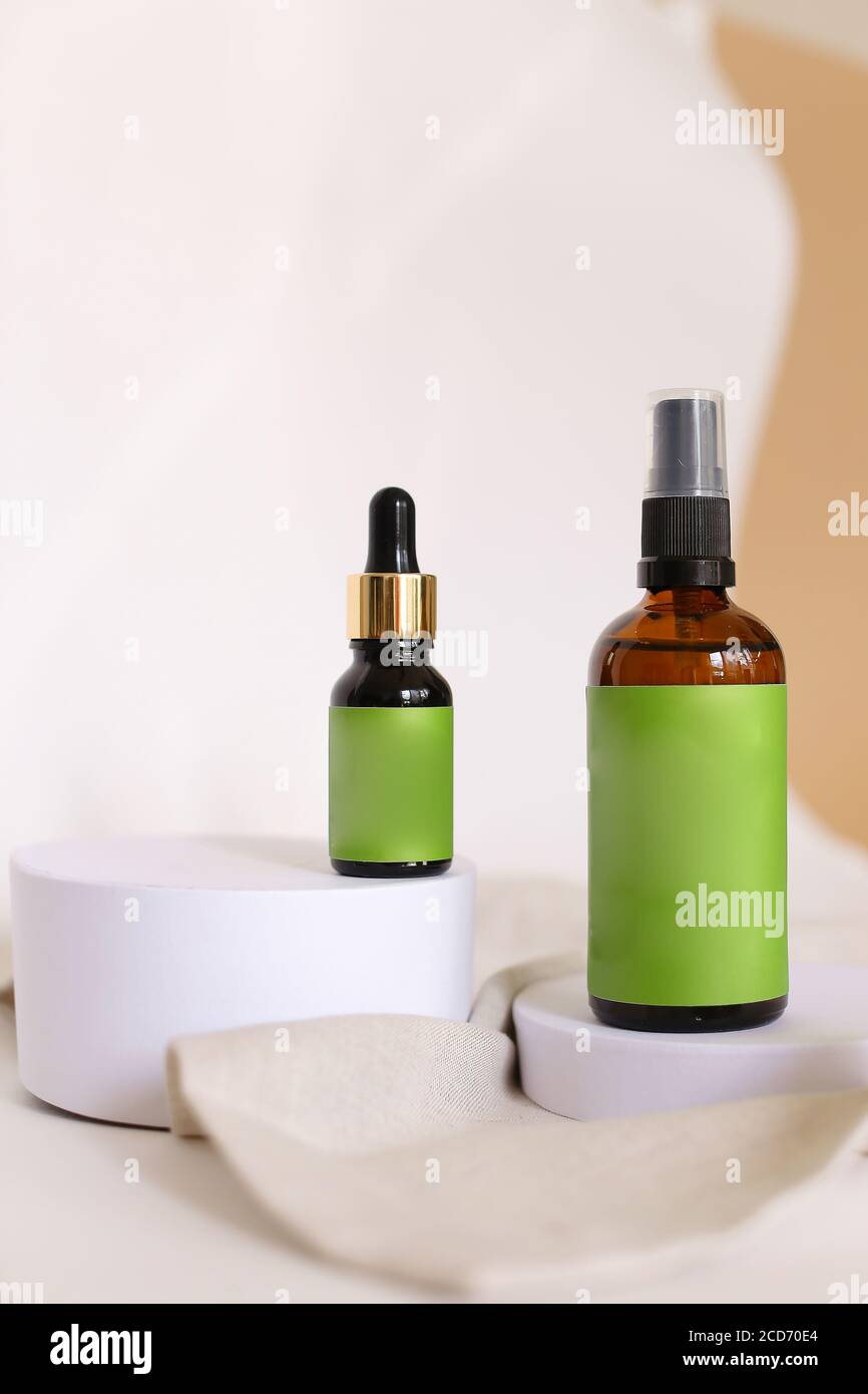 Spray bottle and pipette dropper with cosmetic products and green space ...