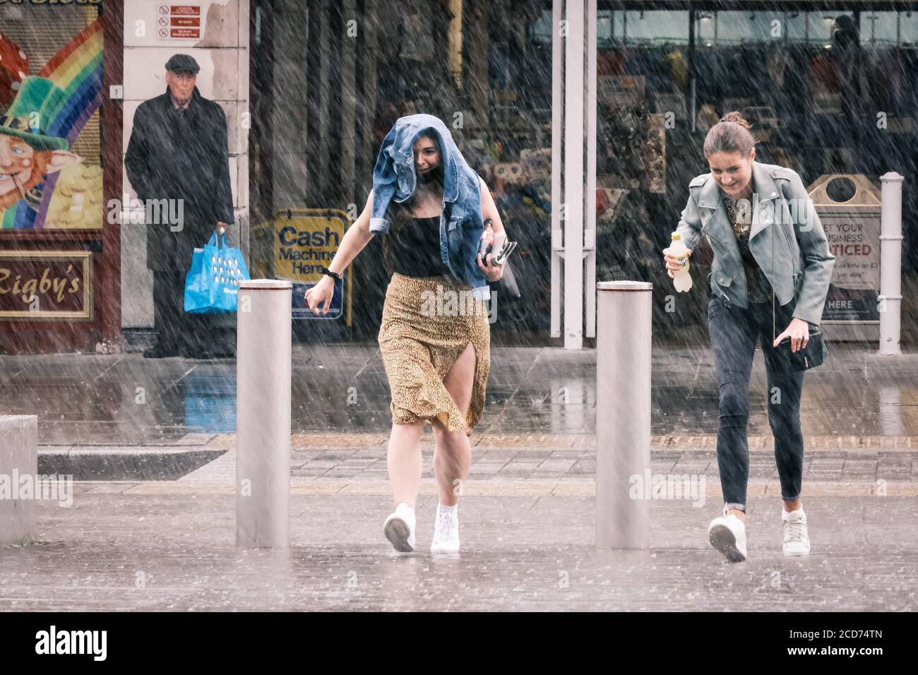 UK Weather Two young women getting caught in a heavy rain shower, Preston, UK Stock Photo Alamy