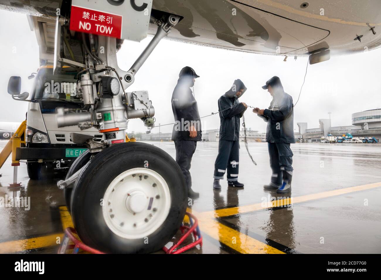 Benxi, China's Liaoning Province. 27th Aug, 2020. Ground crew members conduct pre-flight check on a passenger plane amid a downpour at Shenyang Taoxian International Airport in Shenyang, northeast China's Liaoning Province, Aug. 27, 2020. Typhoon Bavi, the eighth of this year, brought gales and rainstorms to cities in northeast China. Credit: Chen Song/Xinhua/Alamy Live News Stock Photo