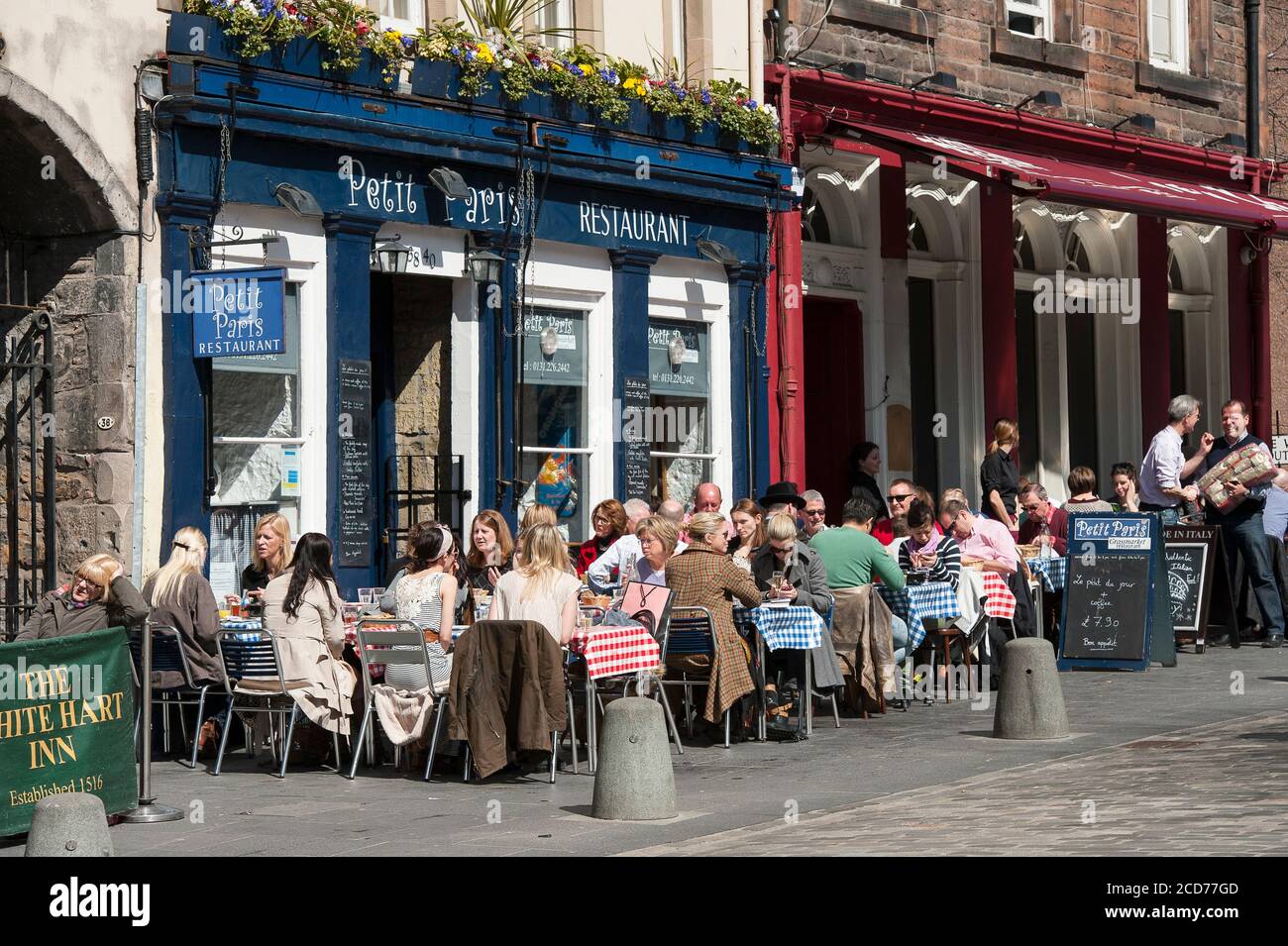 People dining al fresco outside restaurants on a street in the city of Edinburgh, Scotland. Stock Photo