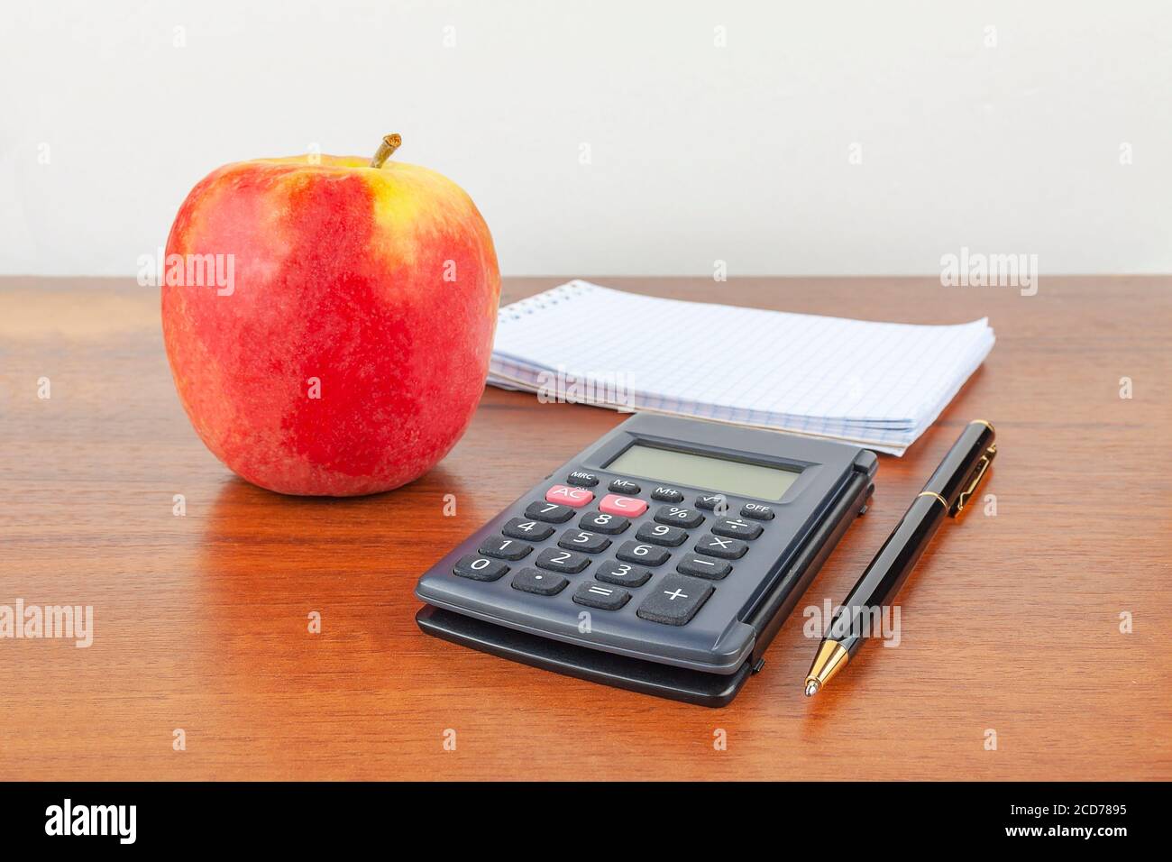 Apple pen notepad calculator lie on the table. Stock Photo
