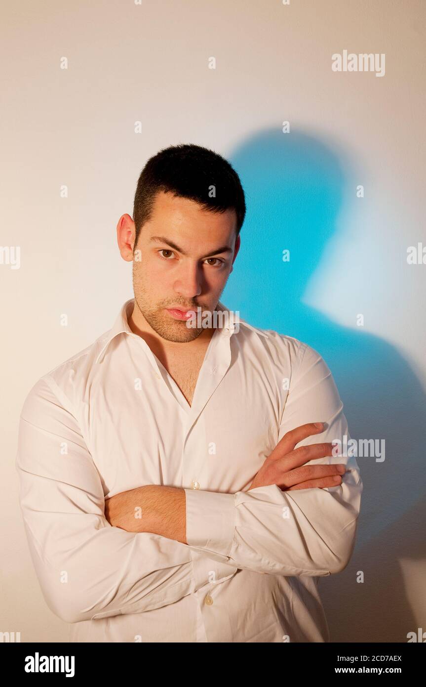 Young man crossing arms, looking at the camera. Stock Photo