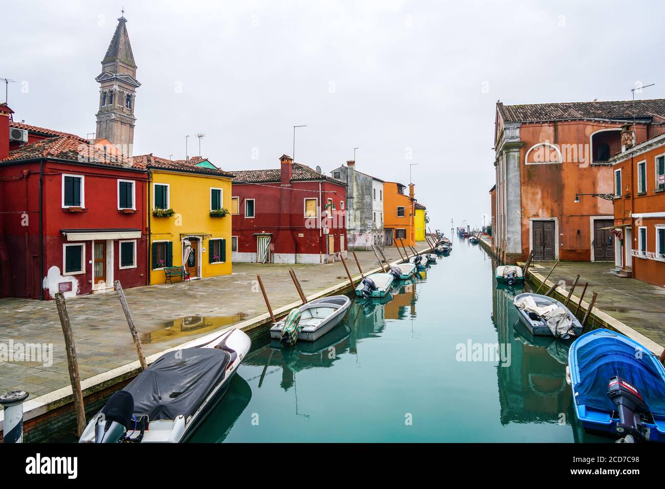 Beautiful canal in Burano with the typical colorful houses and the leaning campanile (bell tower) of San Martino Church. Stock Photo