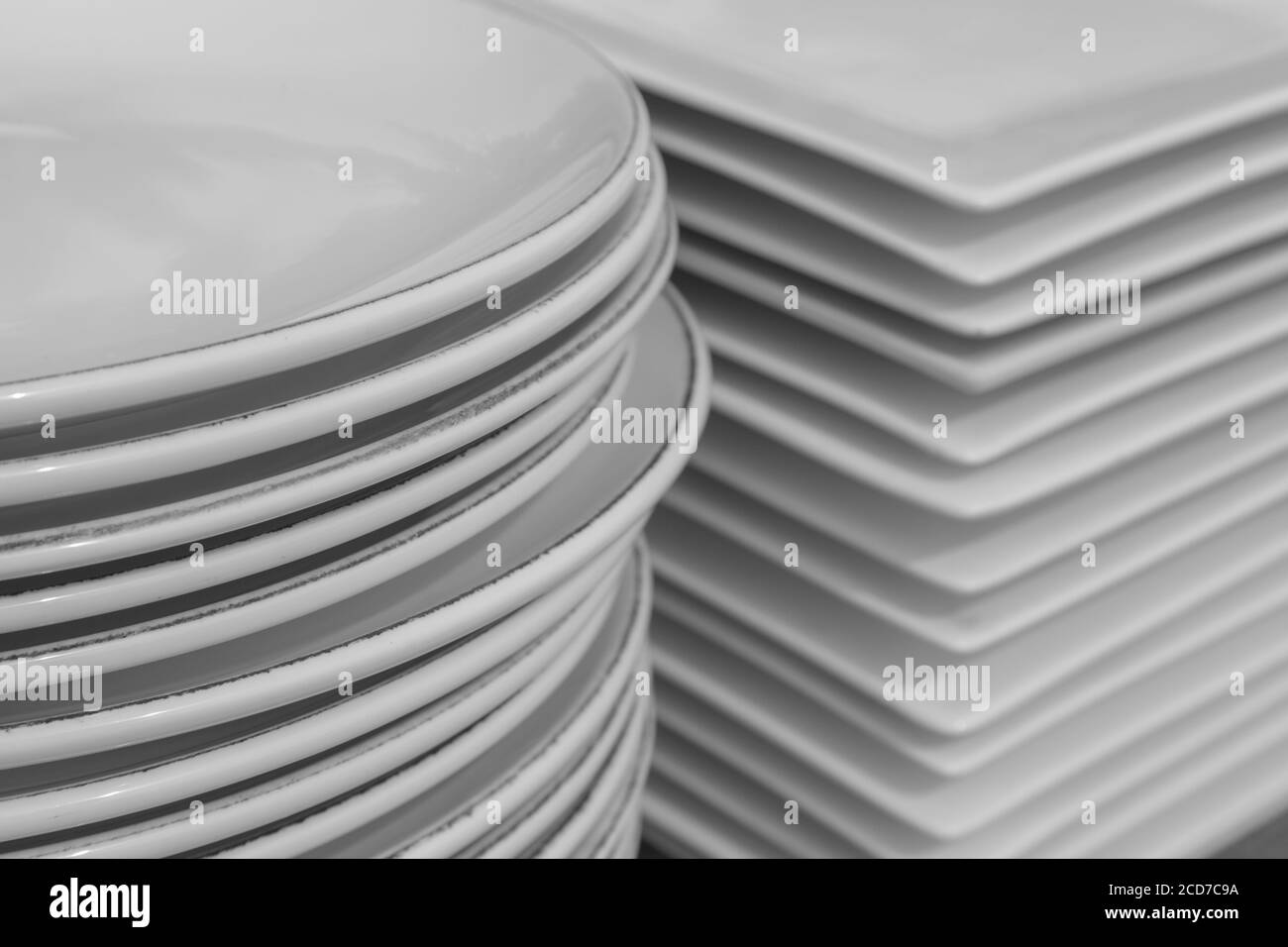 Stack of white porcelain crockery. Ceramic dishware pile. Stock Photo