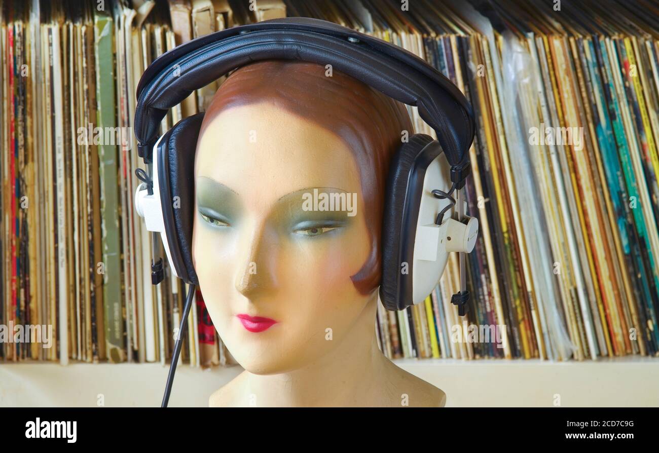 vintage display dummy, mannequin wearing professionell headphones vinyl records in the background, retro analog music concept Stock Photo
