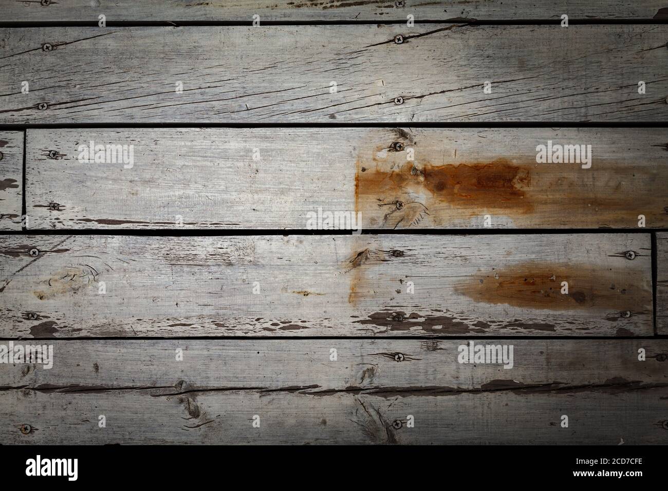Old wooden wall of boards with weathered and peeled white paint. Stock Photo