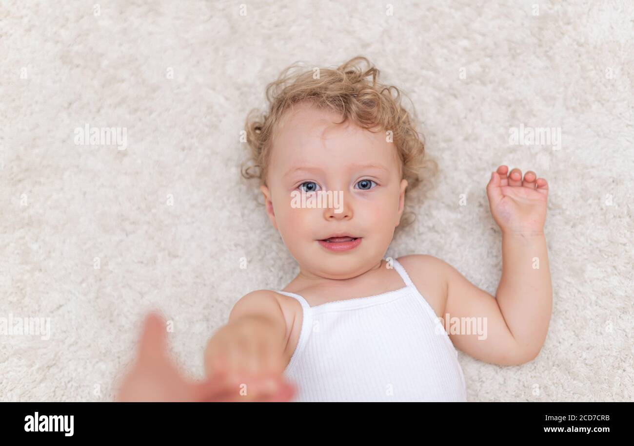 Portrait of a little girl who lies on the carpet Stock Photo - Alamy