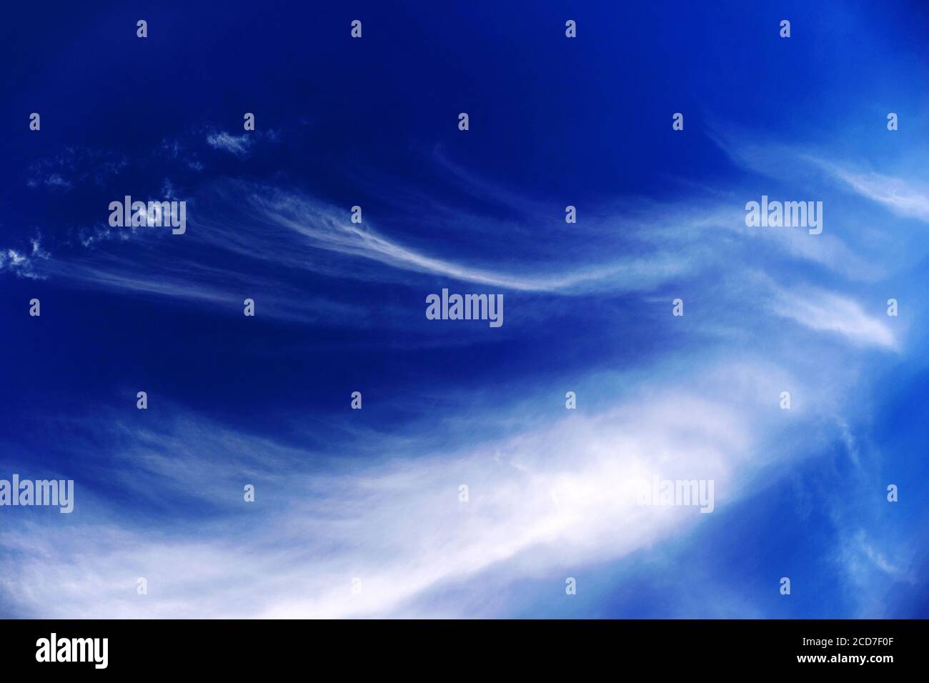 Mares tails high cirrus clouds against deep blue sky Stock Photo