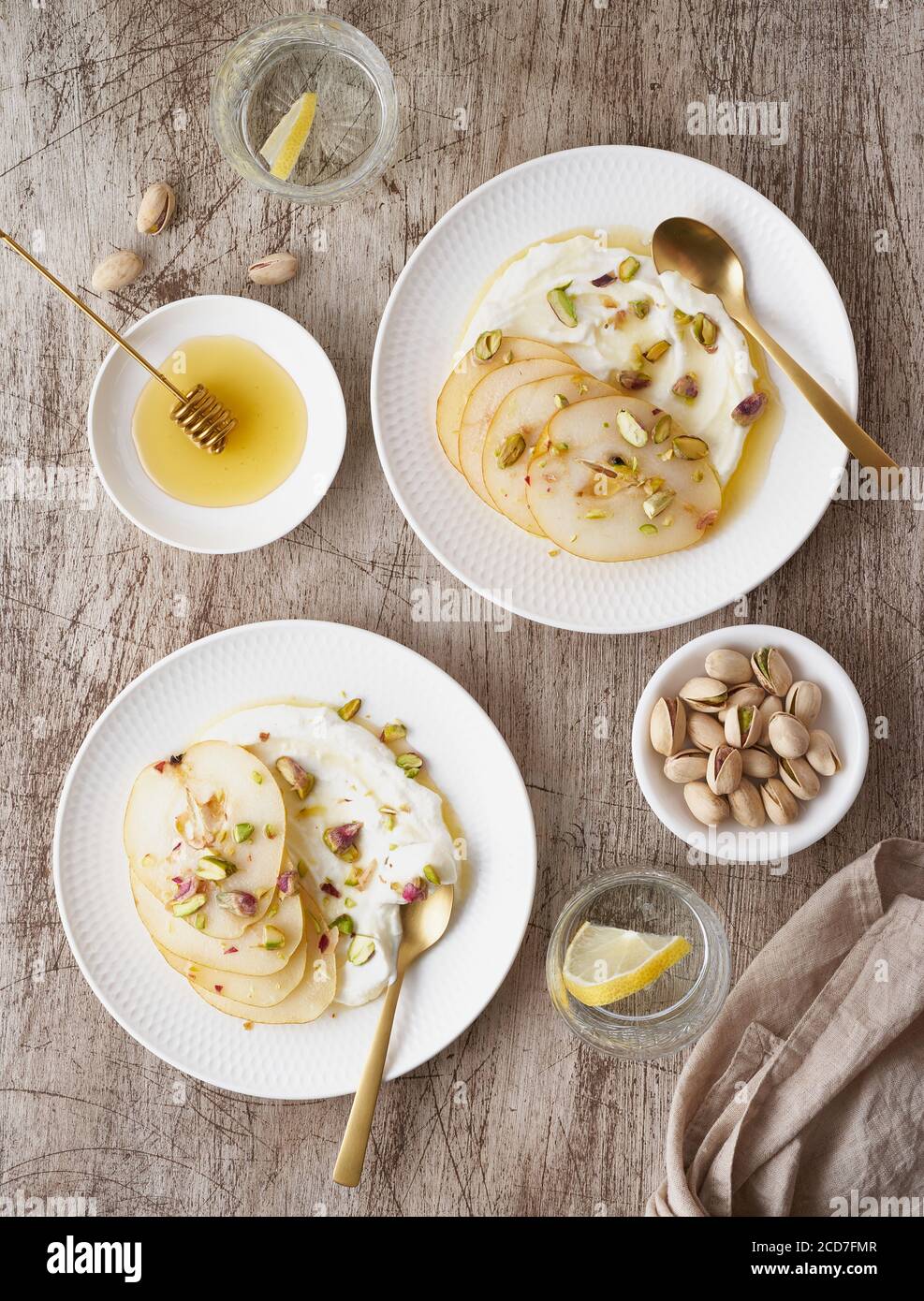 Ricotta with pears, pistachios and honey or maple syrup on two white plate Stock Photo