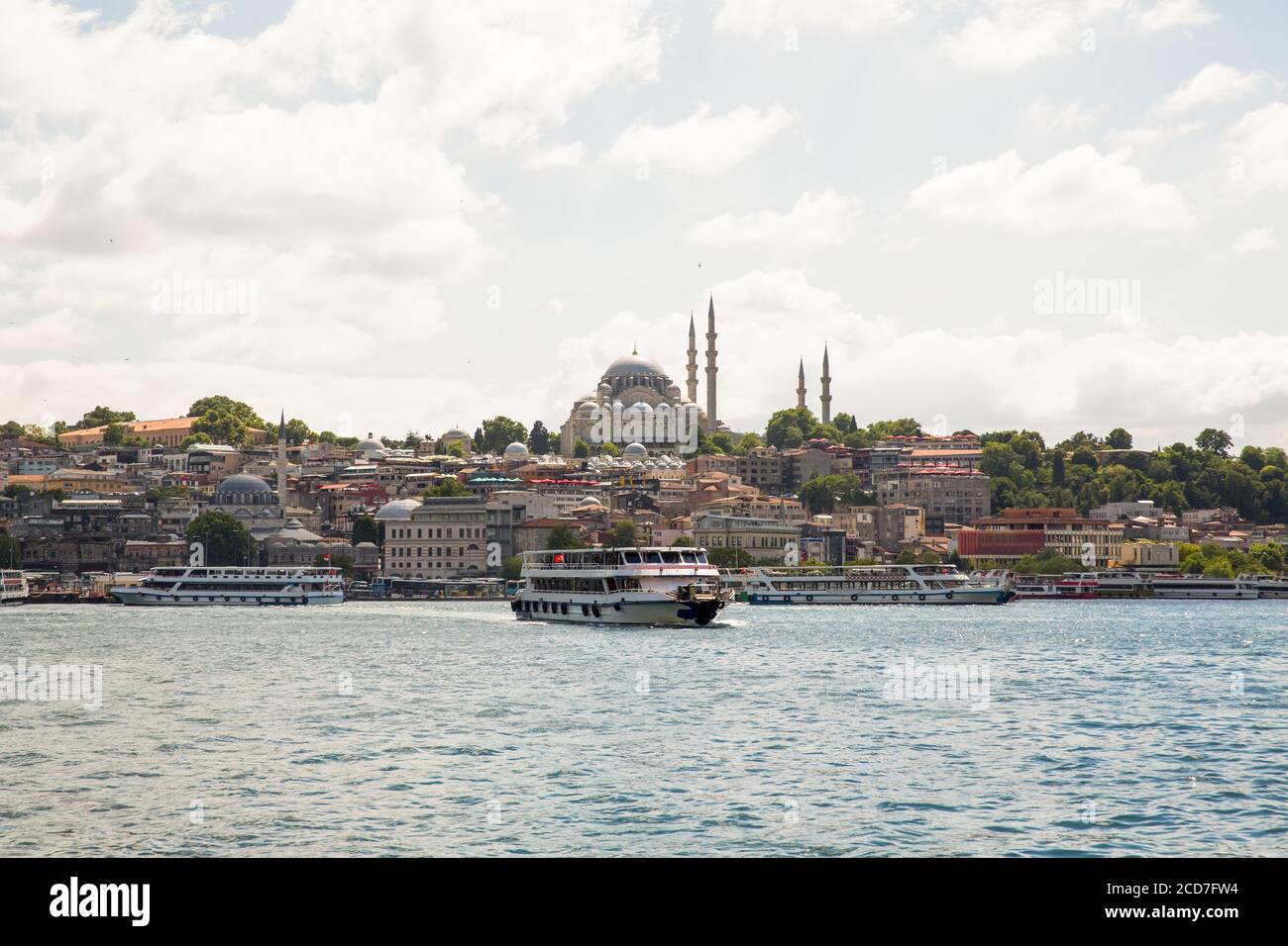 Panoramic shot of the old town Istanbul; The magnificent Suleymaniye Mosque in the Fatih district at sunset ,Eminonu, ferries and boats on the Golden Stock Photo