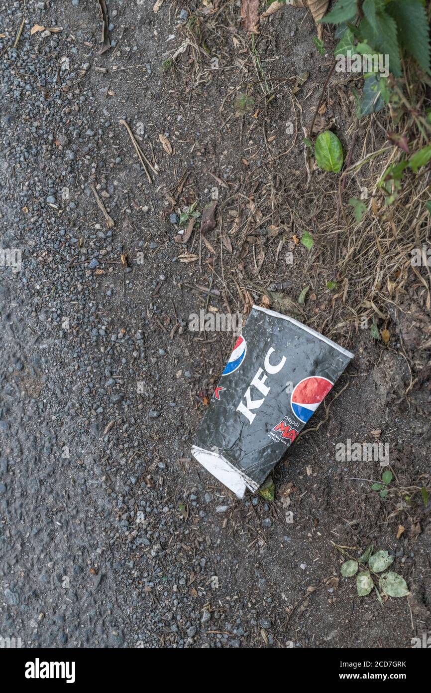 KFC takeaway drinks cup (believed to be paper) on the side of a country road. Concept of takeaway litter, fast food rubbish. Stock Photo