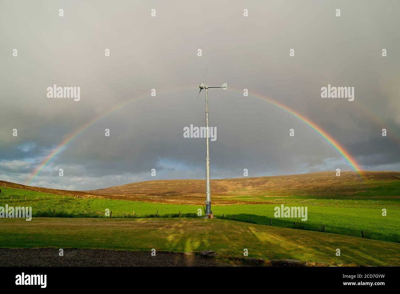 Wind turbine and rainbow, Orkney Isles Stock Photo