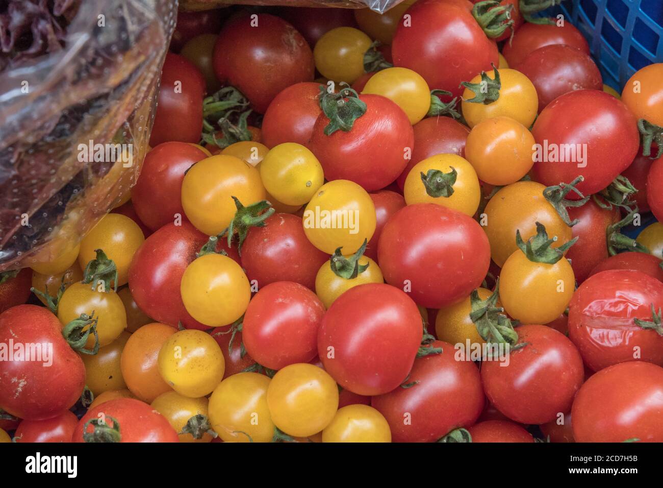 Small red and yellow cherry tomatoes on sale in a corner grocery store ...