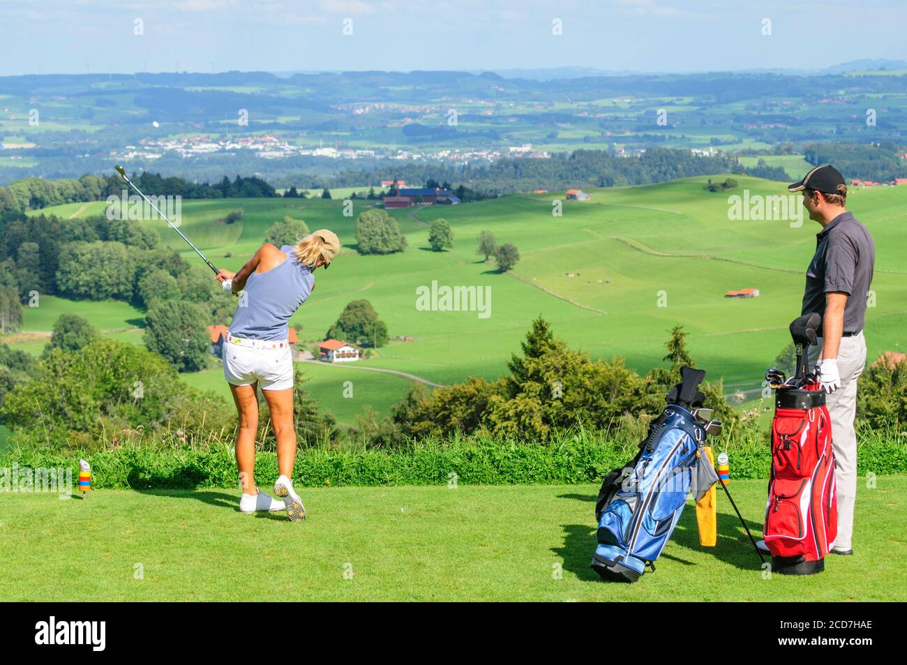 Man and woman playing golf on a beautiful parkland course at a sunny day in summertime Stock Photo