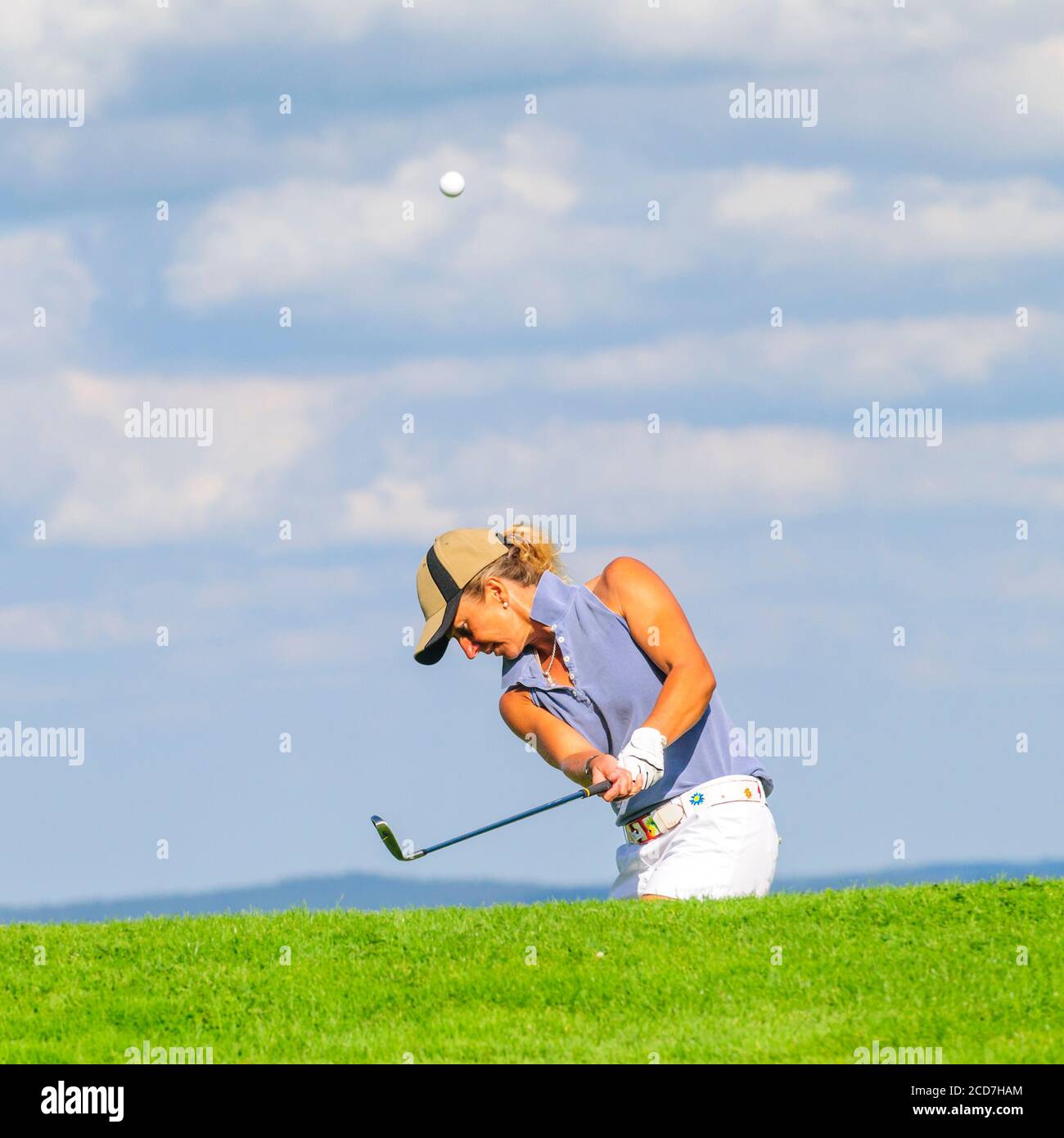 Man and woman playing golf on a beautiful parkland course at a sunny day in summertime Stock Photo