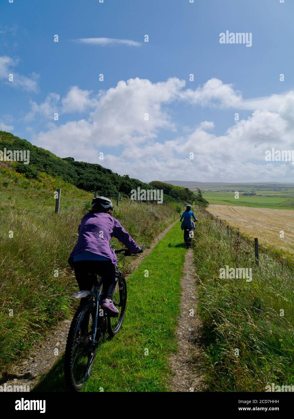 Mother and daughter cycling on farm track, Orkney isles Stock Photo