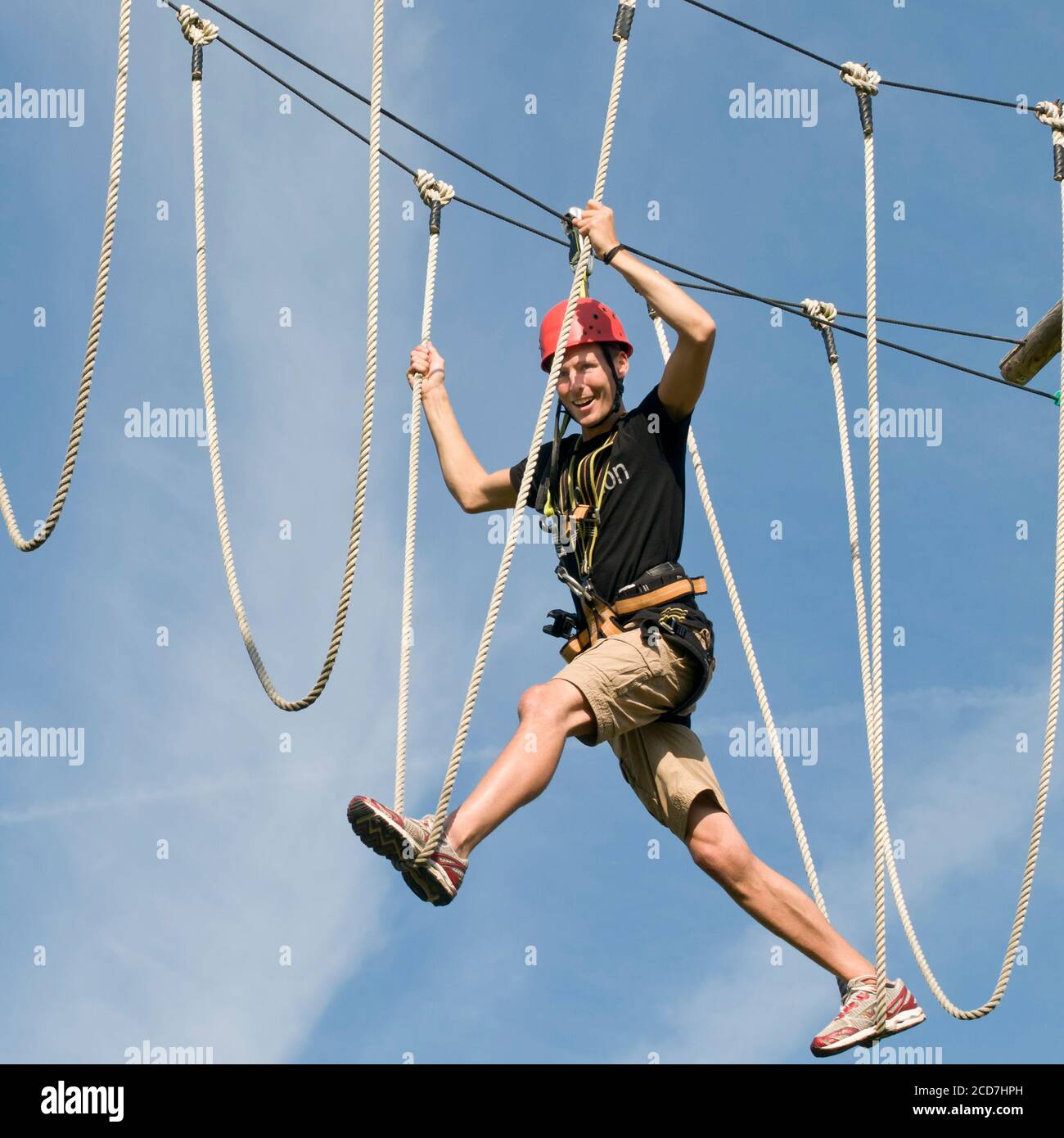 Balance Ropes Course Young man has fun while absolving an balance exercise in high ropes ...