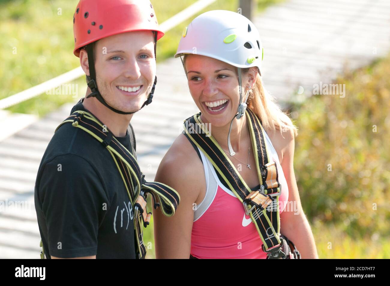 Young people doing exercises in high rope course at a sunny day Stock Photo