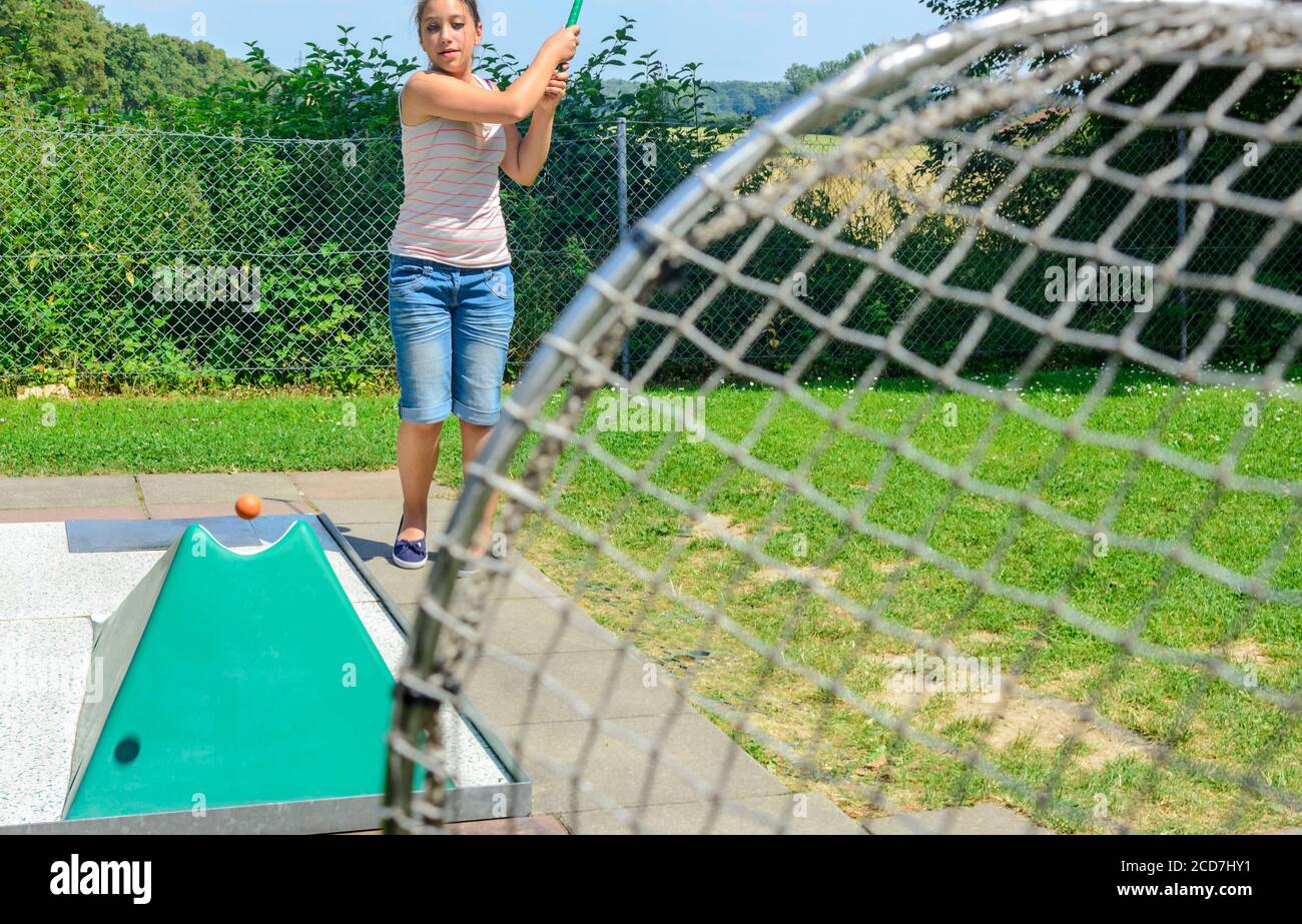 Woman with kids playing miniature golf on sunny day Stock Photo