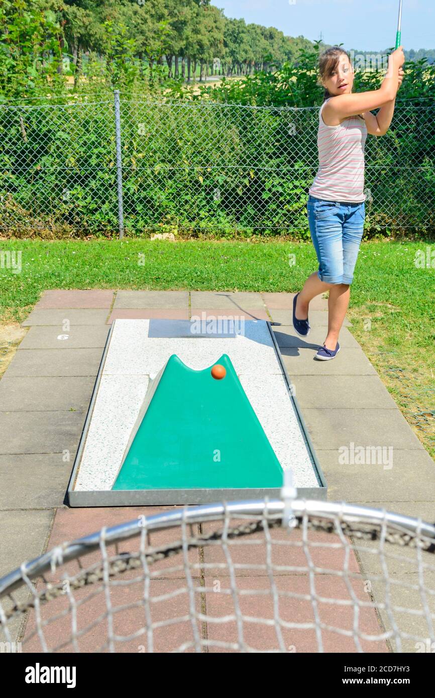 Woman with kids playing miniature golf on sunny day Stock Photo