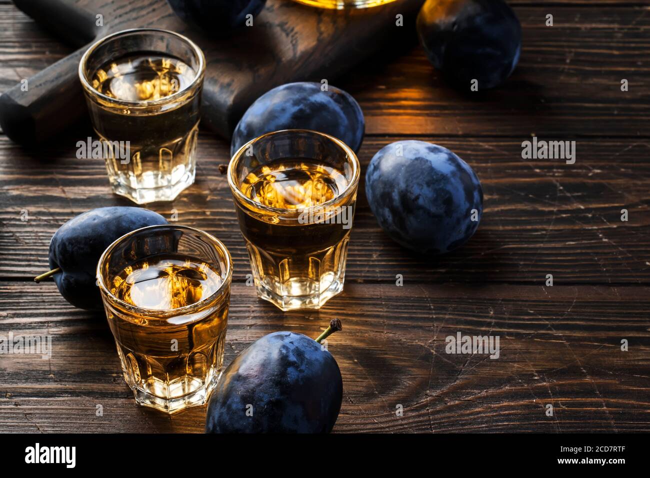 Slivovica - plum brandy or plum vodka, hard liquor, strong drink in glasses  on old wooden table, fresh plums, copy space Stock Photo - Alamy