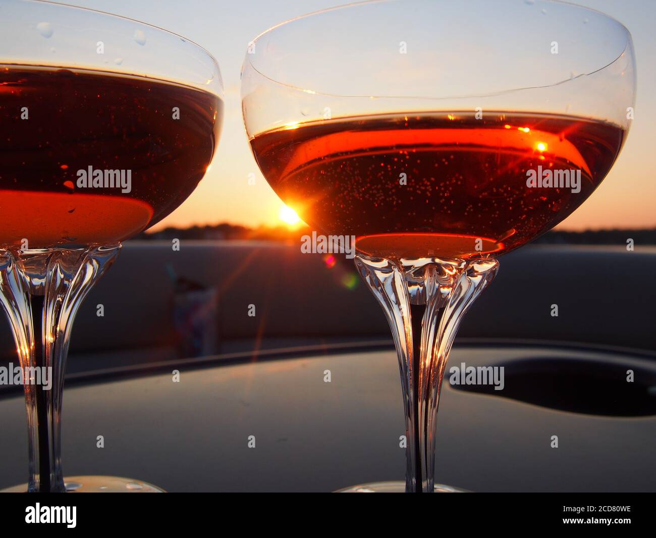 A Pair of champagne glasses filled with rose' at sunset Stock Photo