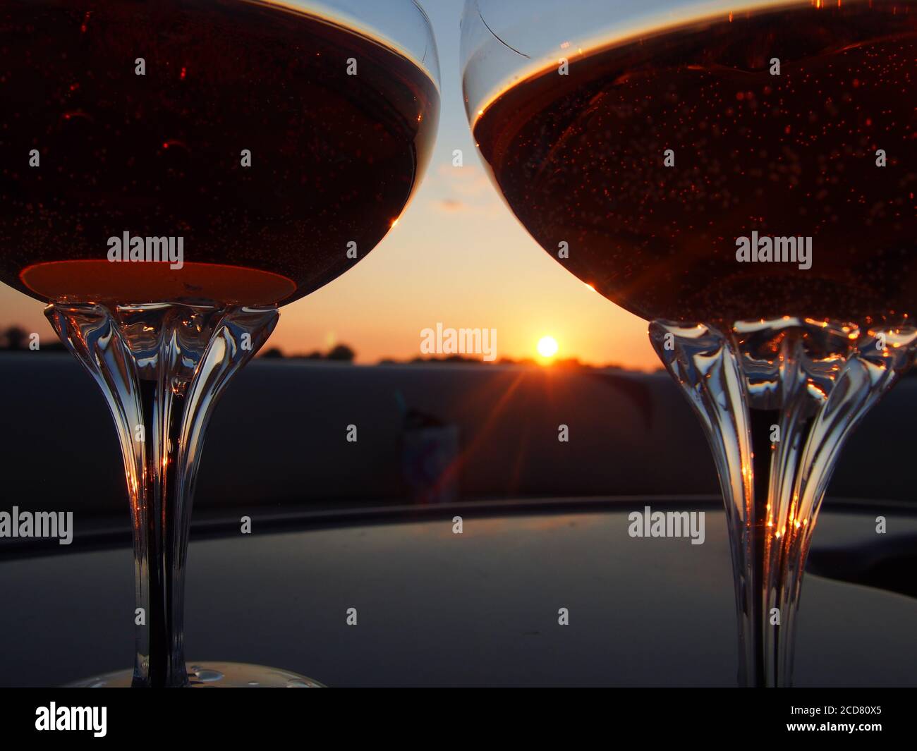 A Pair of champagne glasses filled with rose' at sunset Stock Photo