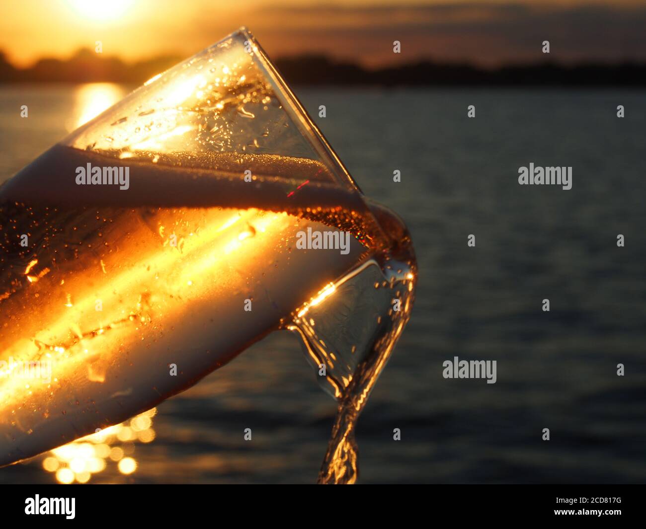 Champagne' Being Poured Against Lake Sunset Stock Photo