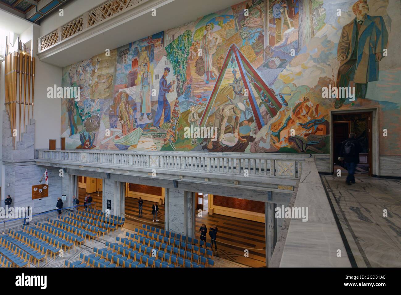 Tourists and staff in Oslo City Hall against the wall painting by Henrik Sørensen, Oslo, Norway Stock Photo