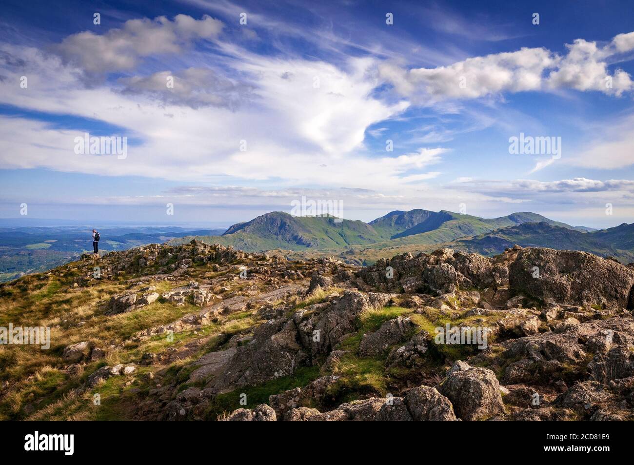 A lonely fellwalker  with The Bend and Bow Fell seen from the top pf the Langdale Pikes. Lake district Stock Photo