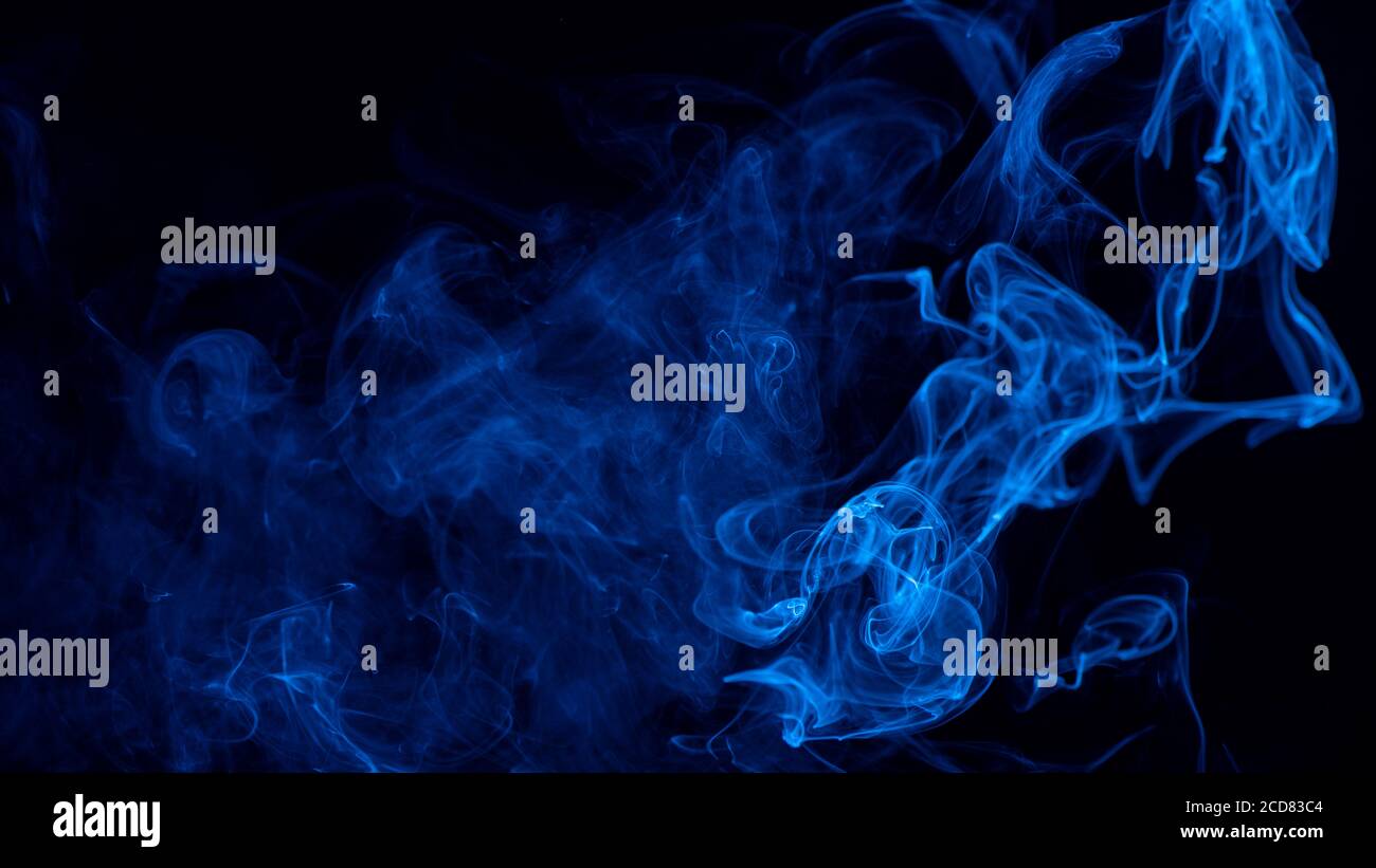 Conceptual image of blue color smoke isolated on dark black background ...