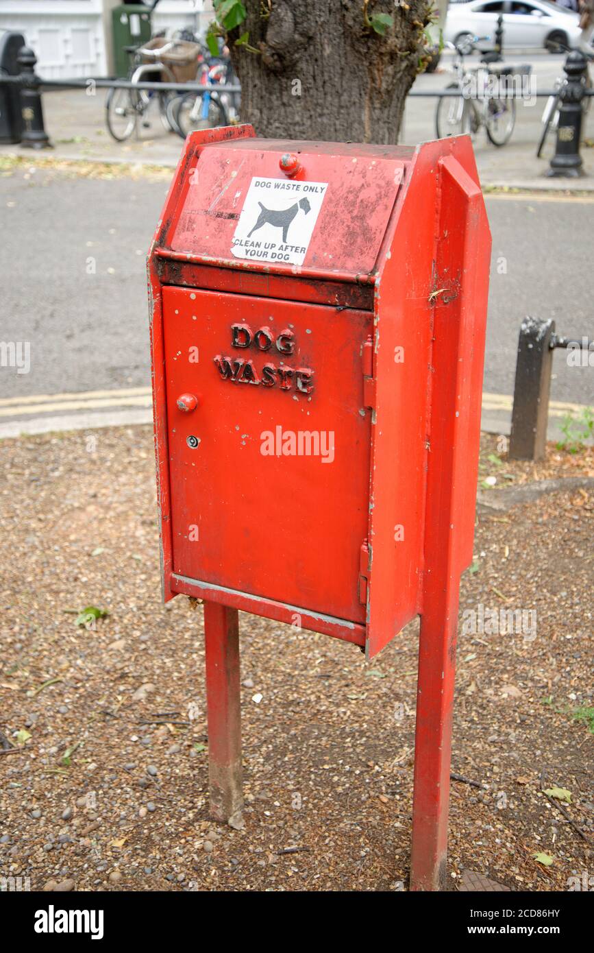 Dog waste bin. A red municipal receptacle for dog poo. Clean up after your dog. Emptied weekly by council workers. Stock Photo