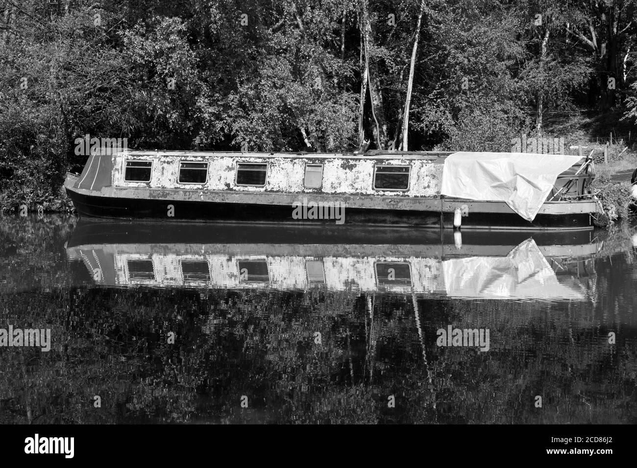 This old boat has seen better days, and is now moored along the beautiful Wey Navigation in Surrey Stock Photo