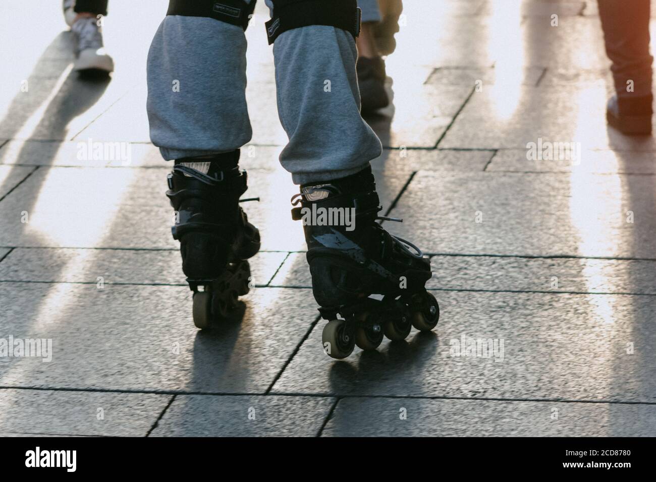 roller skating on the sidewalk tacking between people lifestyle Stock
