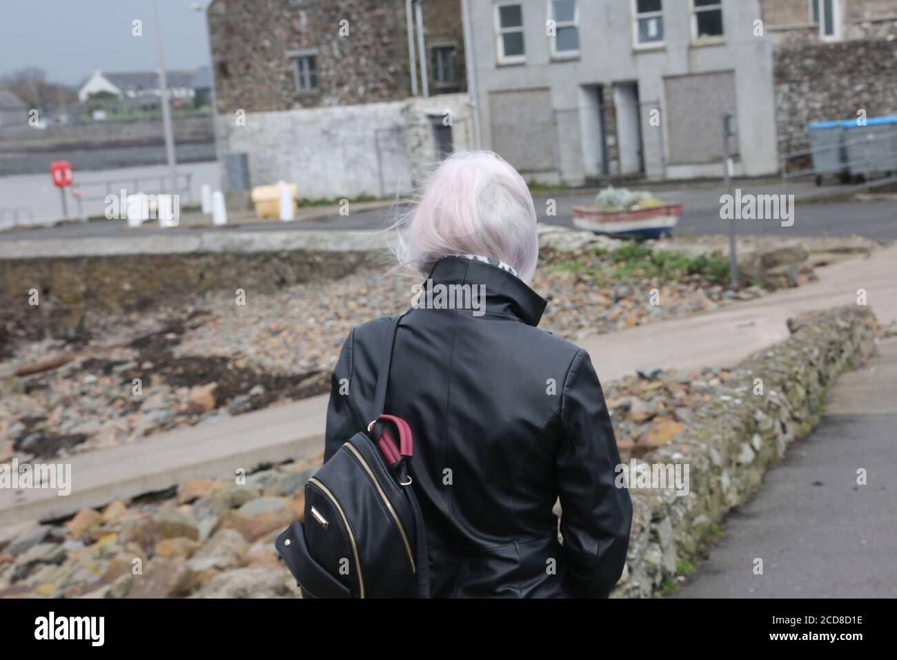 Caucasian white middle aged woman in long leather coat ,collar turned