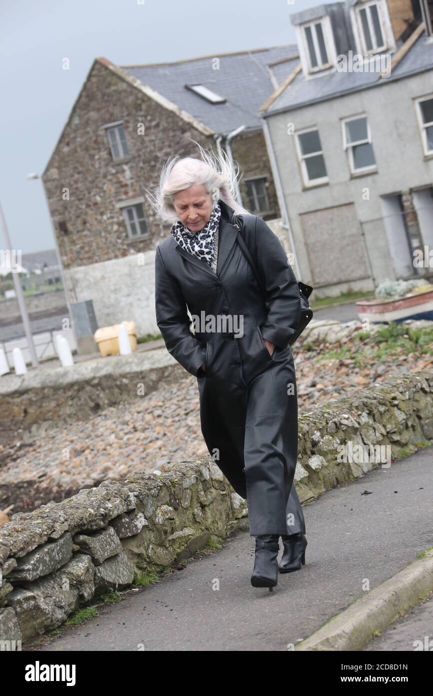 Caucasian white middle aged woman in long leather coat ,collar turned