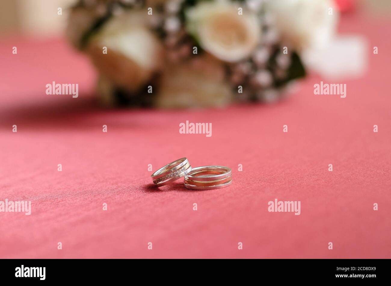 Gold wedding rings are on the pink table. Close up Stock Photo