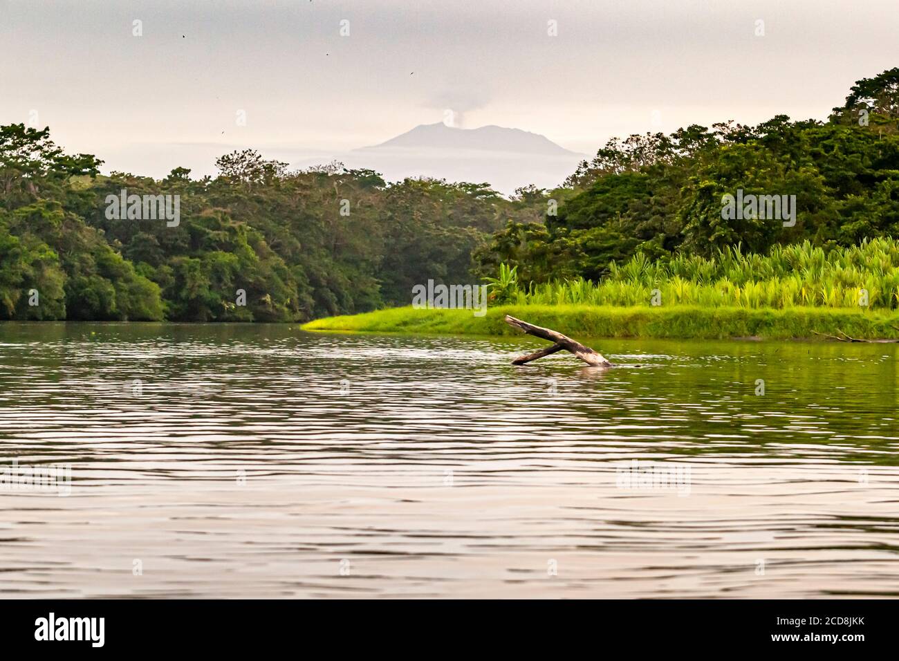 Volcano on the horizon behind a canal near Pacuare on the Atlantic ocean near Reventazón, Costa Rica Stock Photo