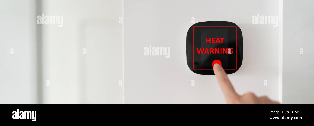 Air conditioning smart home digital screen device regulating indoor temperature during summer heat wave showing heat warning online Stock Photo