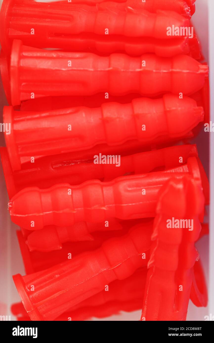 Red plastic dowels for self-tapping screws close-up. Stock Photo