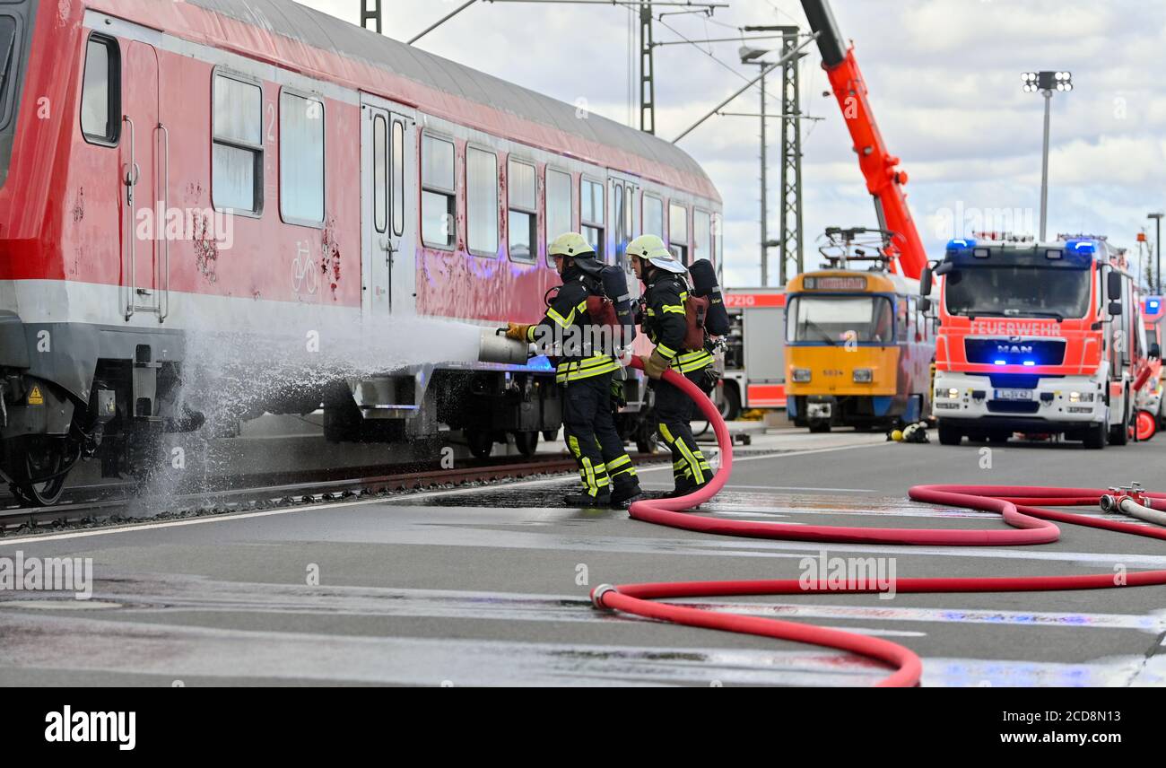 27 August 2020, Saxony, Leipzig: In the fire brigade technical training  centre, firefighters from the Leipzig professional fire brigade demonstrate  fire fighting on a train carriage. In a three-year pilot project, the