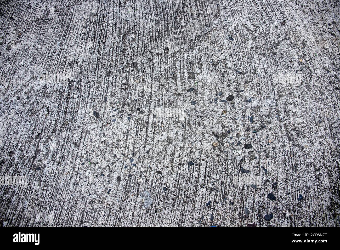 Weathered scratched concrete surface photo texture. Grunge concrete road perspective view. Rough concrete or asphalt surface with gravel. Weathered ro Stock Photo