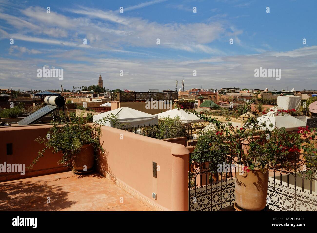 View of roof terrace in Marrakech. Morocco, close to the city centre. Rooftops with tent against shade and solar water heater and view towards Stock Photo