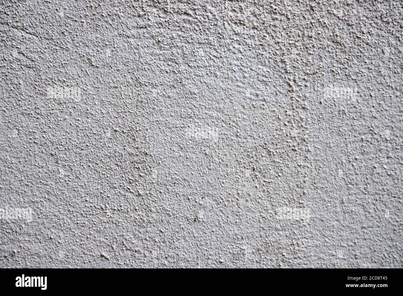White plaster painted wall with grit and noise. Cracked wall closeup