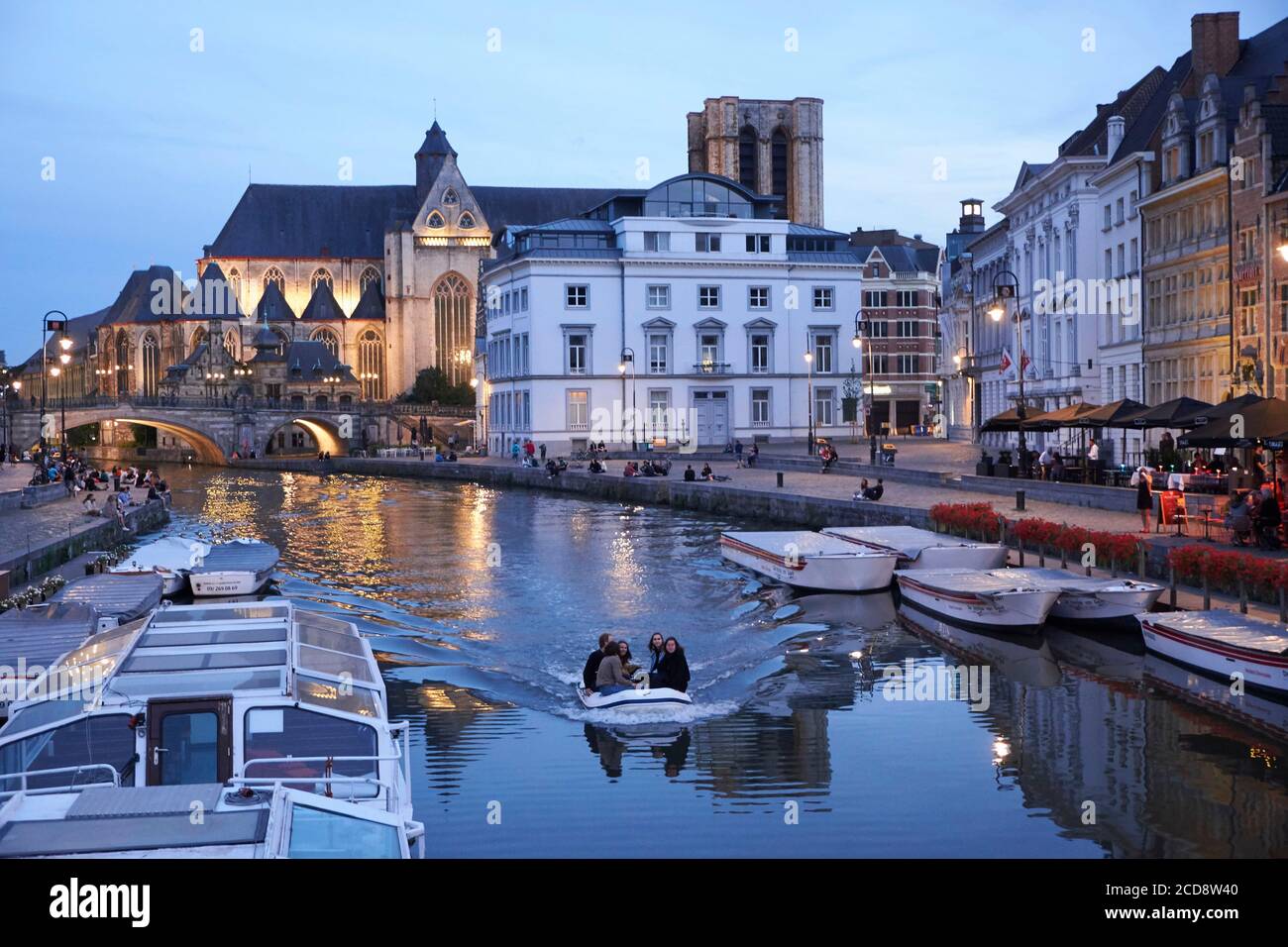 Belgium, East Flanders, Ghent, Night navigation on the Lys river along the Graslei (Herbs Quay) and the Saint Michel church in the background Stock Photo