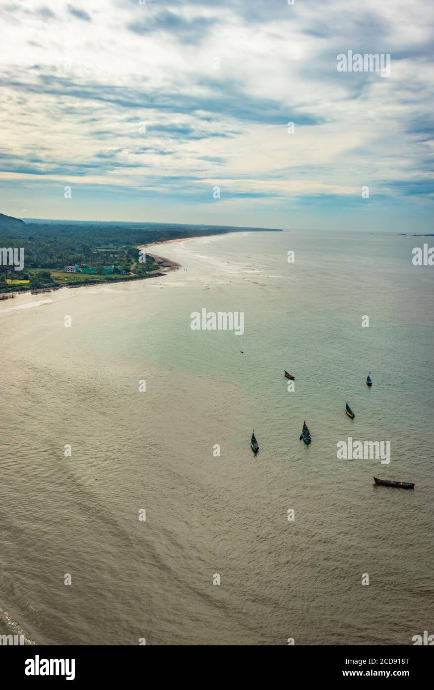 beach isolated with fishing boats aerial shots with dramatic sky image is take at murdeshwar karnataka india at early morning. it is the very holy as Stock Photo